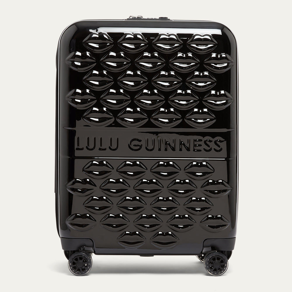Black suitcase with a lip pattern and Lulu Guinness branding on a white background