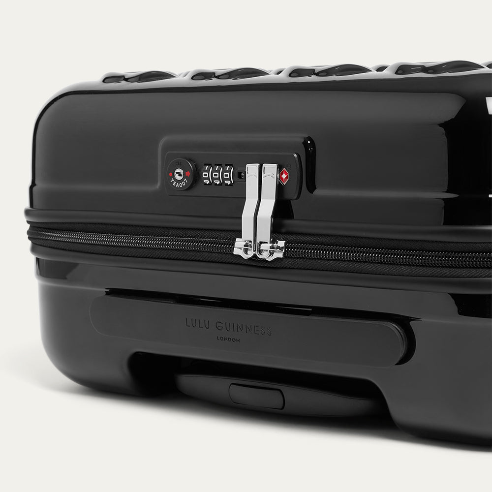 Black suitcase with a visible brand logo on a white background