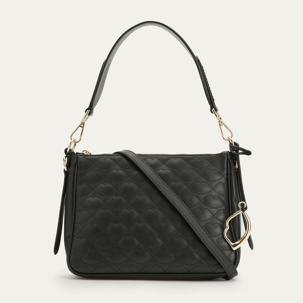Black quilted handbag with gold accents on a light gray background
