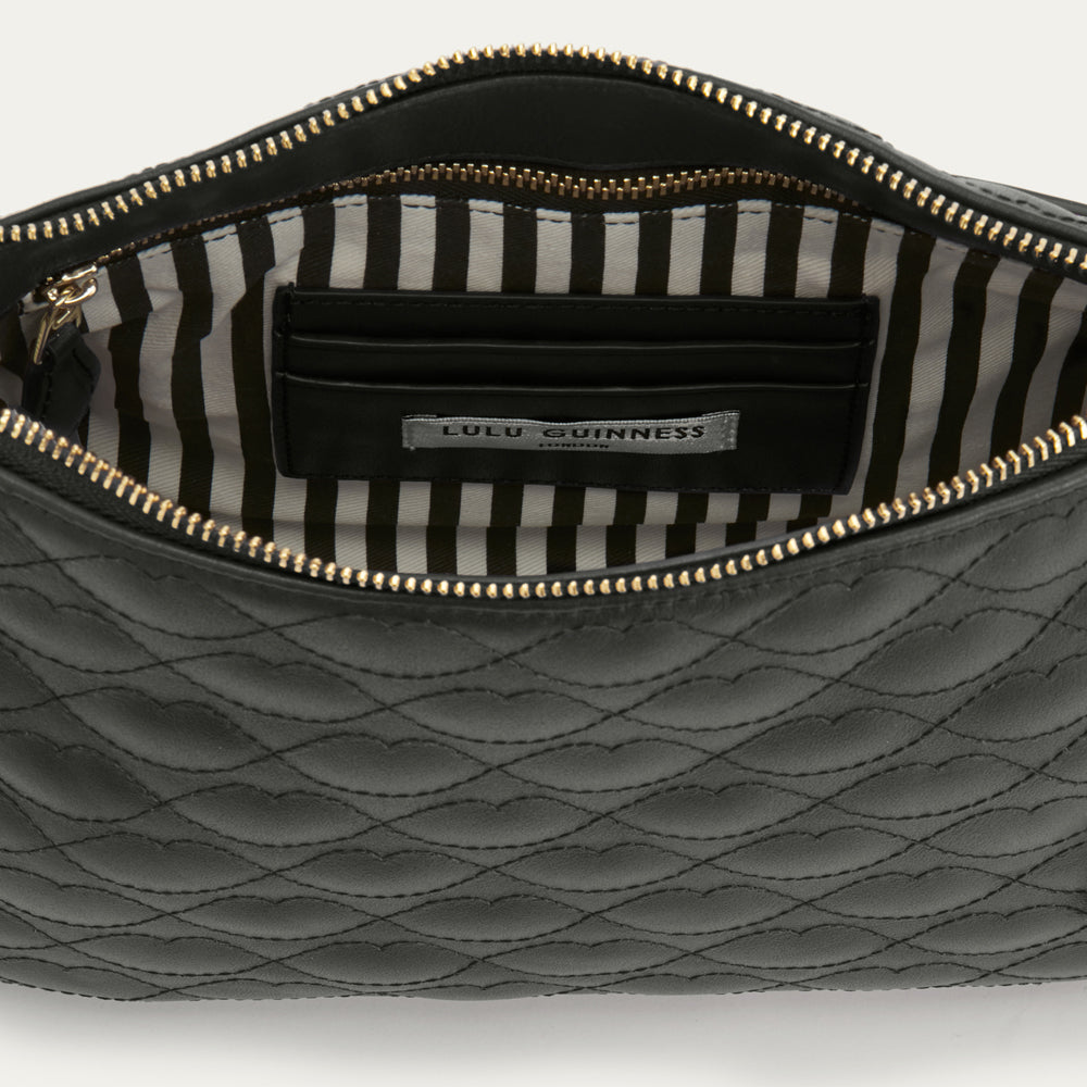 Black quilted handbag with striped lining on a white background