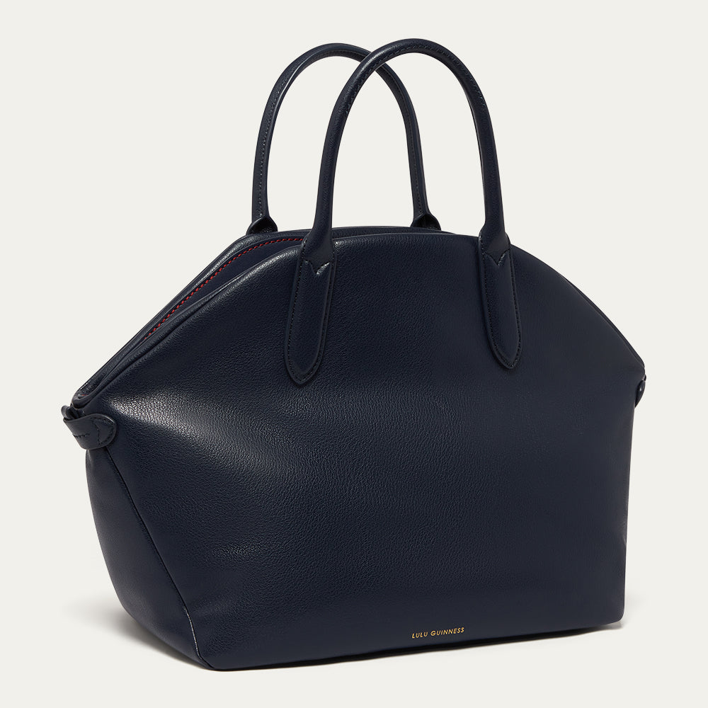 Navy blue leather tote bag with a printed 'Lulu Guinness' logo on a light gray background