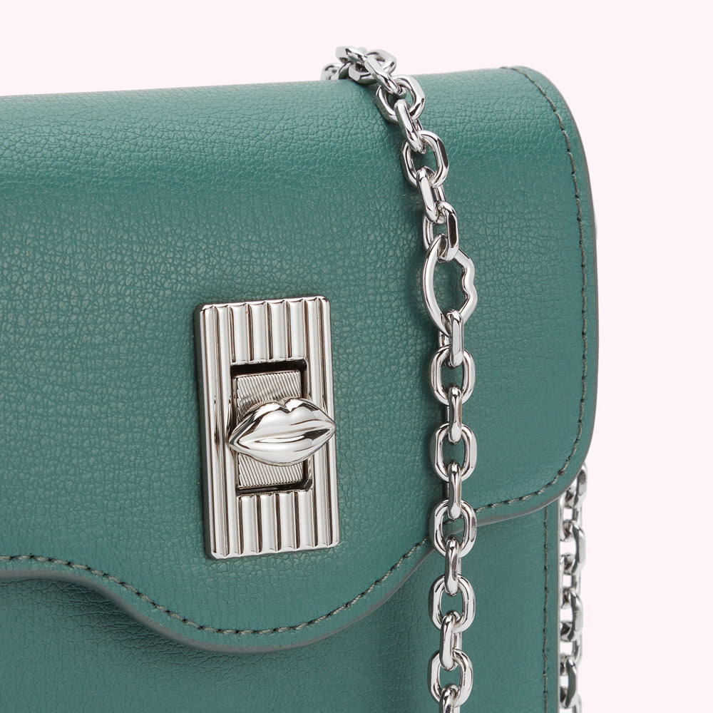 Close-up of a teal leather purse with a silver chain strap and a lip-shaped clasp.
