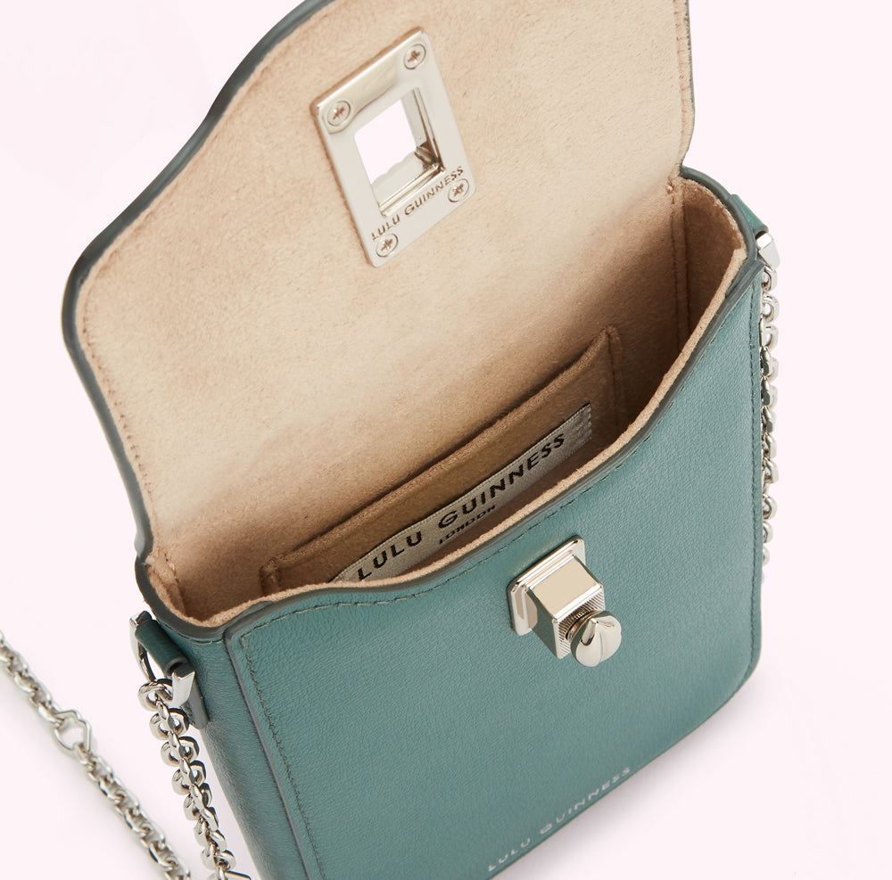 Teal Lulu Guinness crossbody bag with silver hardware and chain strap, open to reveal beige interior.
