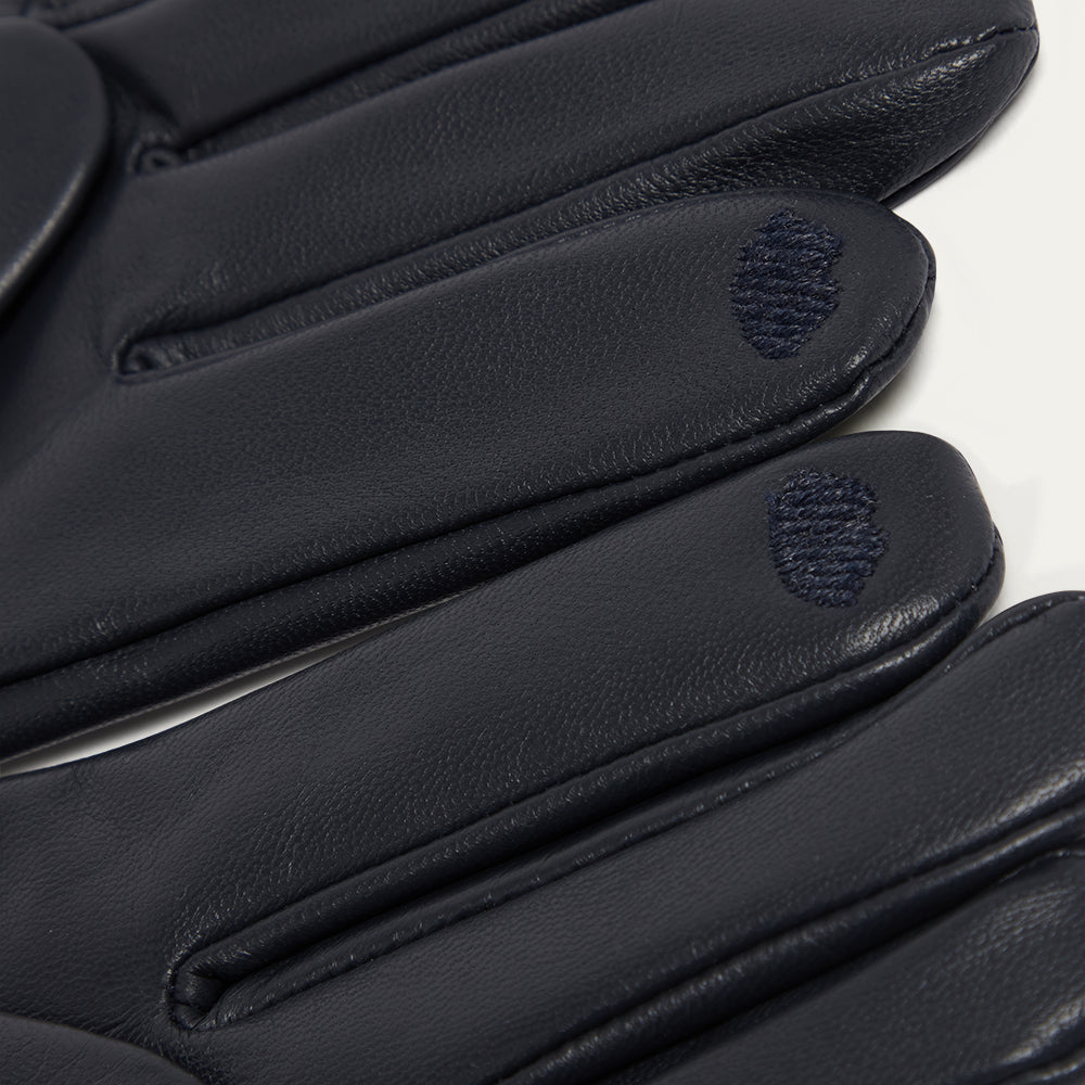 Close-up of navy leather gloves with brand logo on a white background