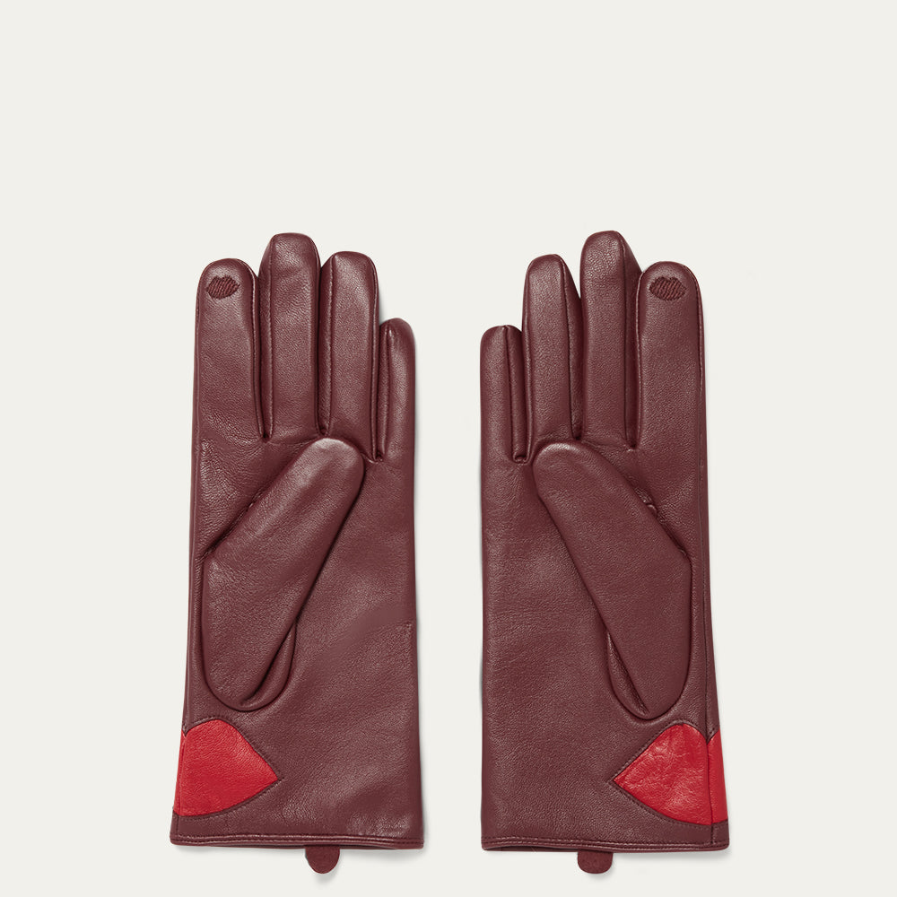 Burgundy leather gloves with red lips on a white background.