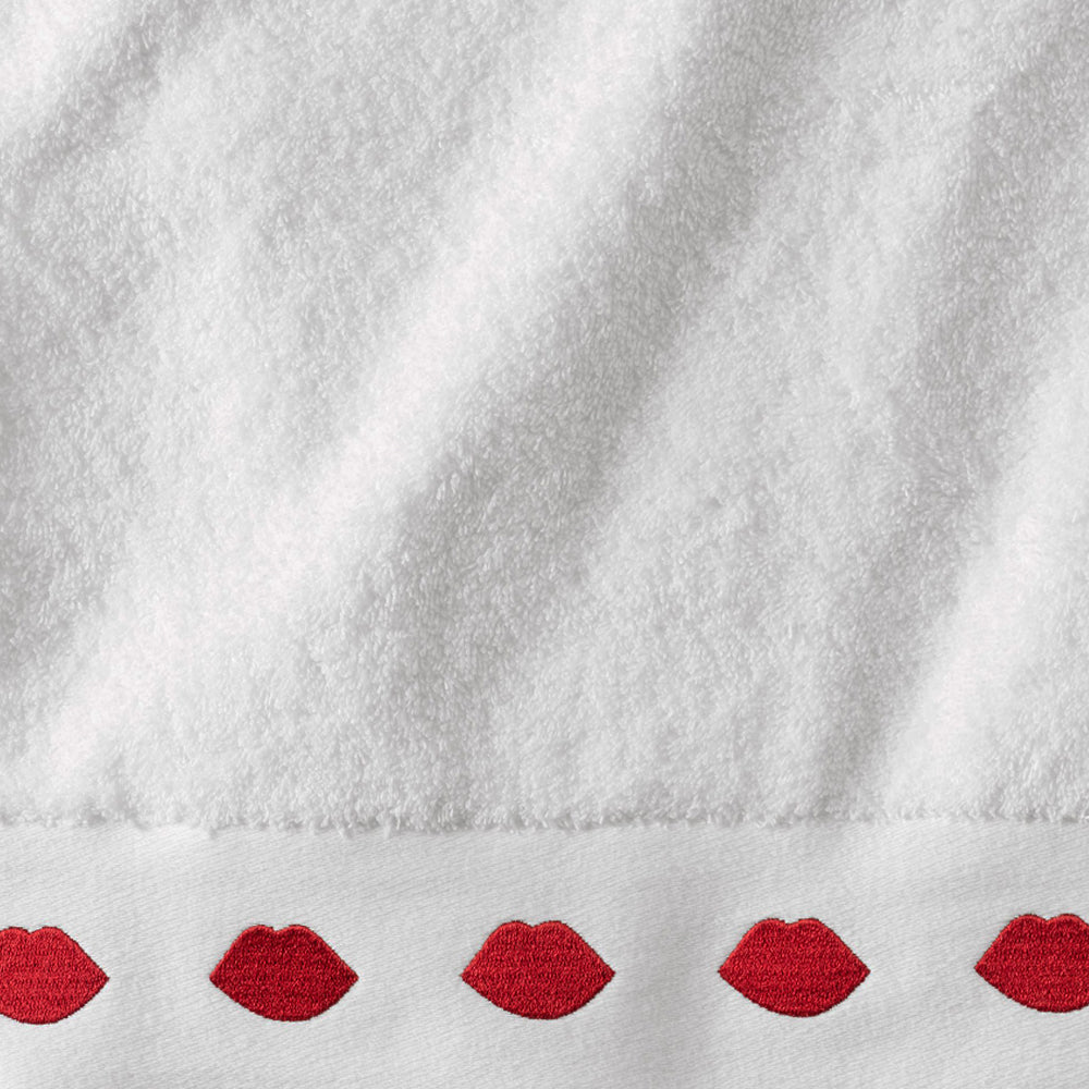 Close-up image of a white hand towel with a row of red lips on the edge