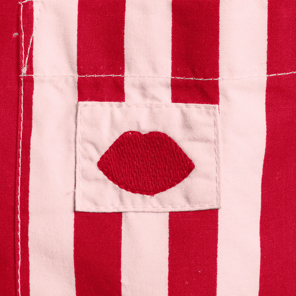 Close-up of a red and pink striped pyjama shirt with a red lip design.