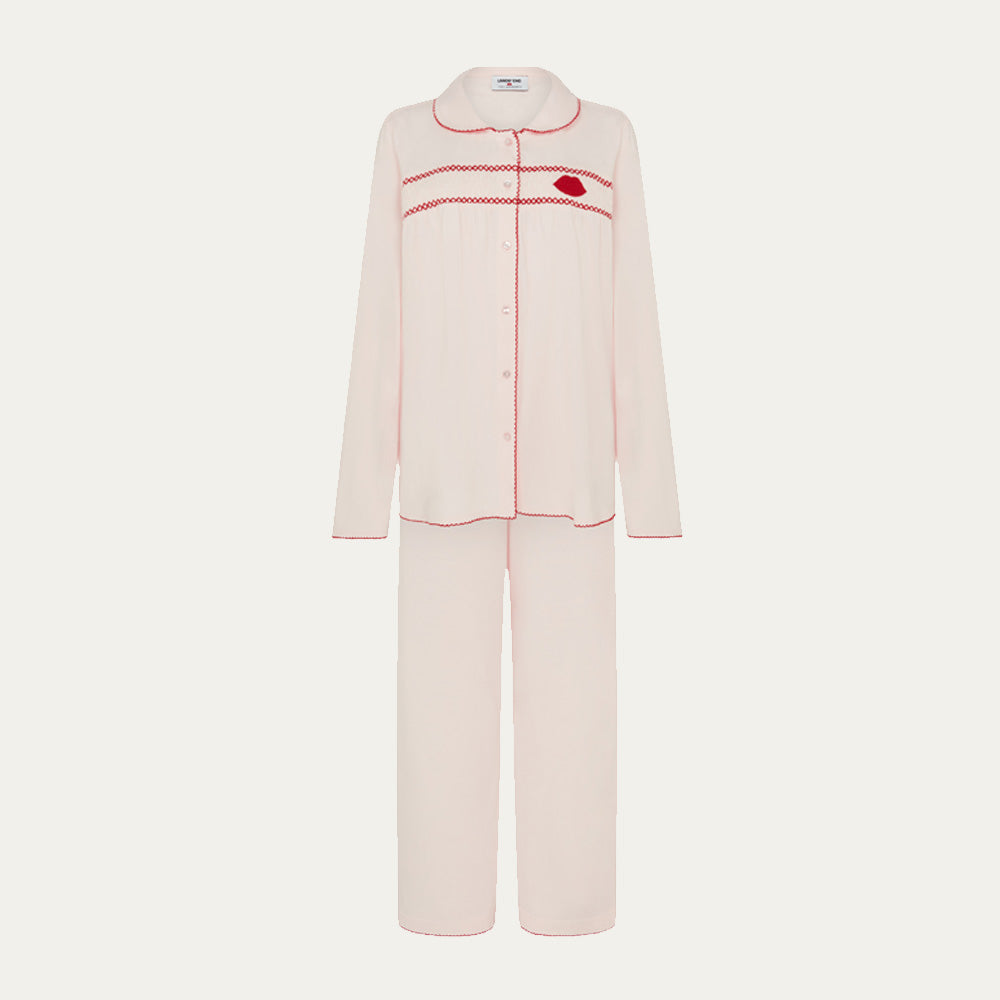 Pink pajama set with red stitching on a white background