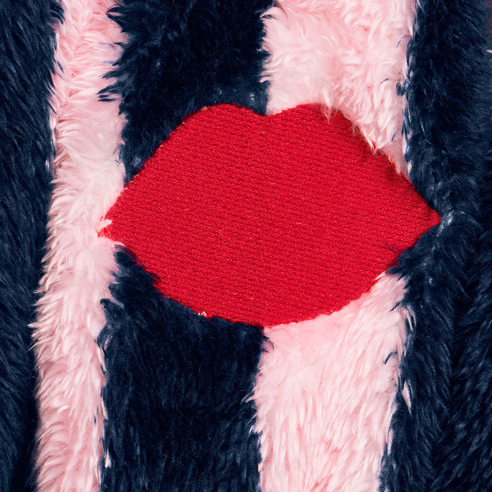 Close-up of a red embroidered lip on the front of a navy and pale pink striped robe