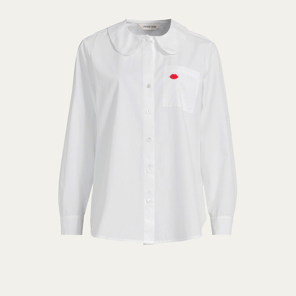 White cotton shirt with a round peter pan collar and red embroidered lip on the pocket against a beige background