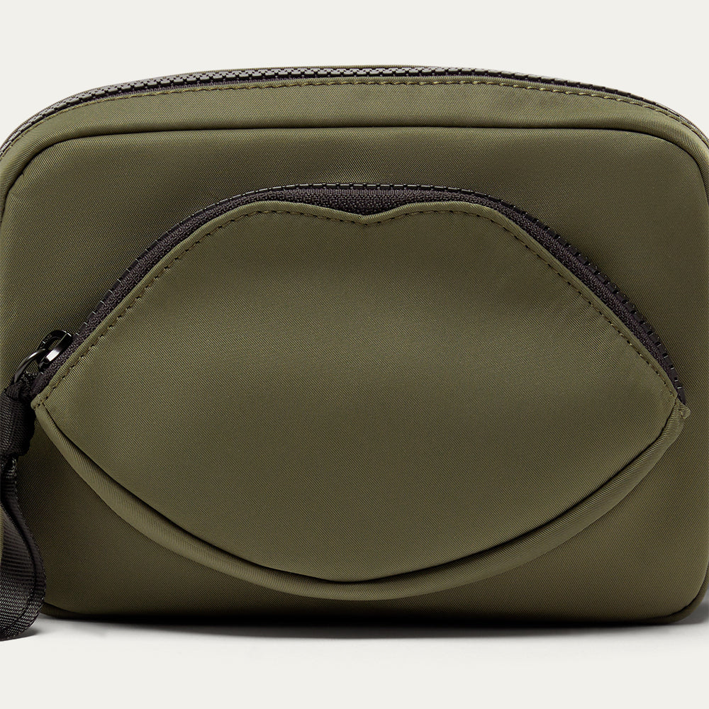 Green crossbody bag with a black zipper on a white background