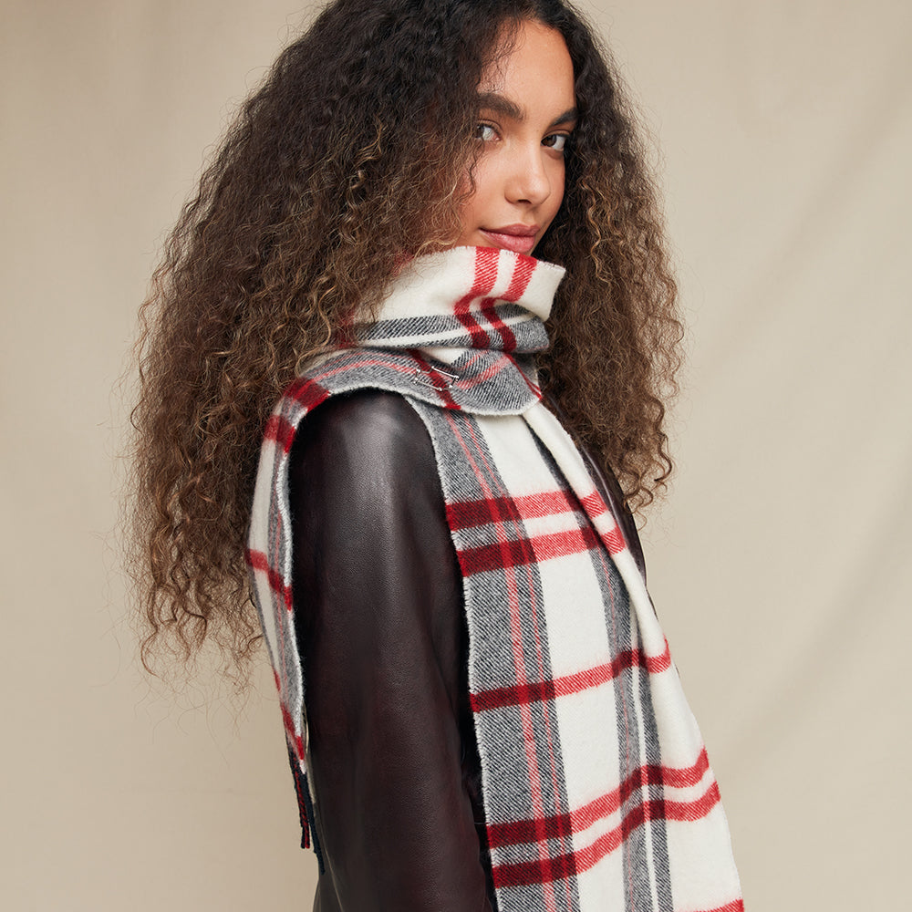 Woman wearing a plaid scarf with a neutral background