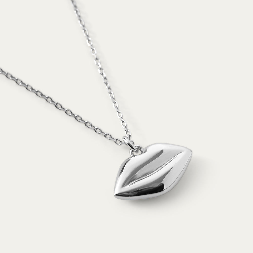 Silver lip-shaped pendant on a chain against a white background