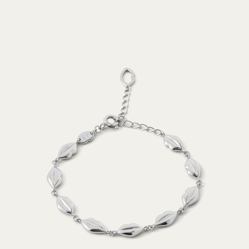 Silver bracelet with lip-shaped links on a white background