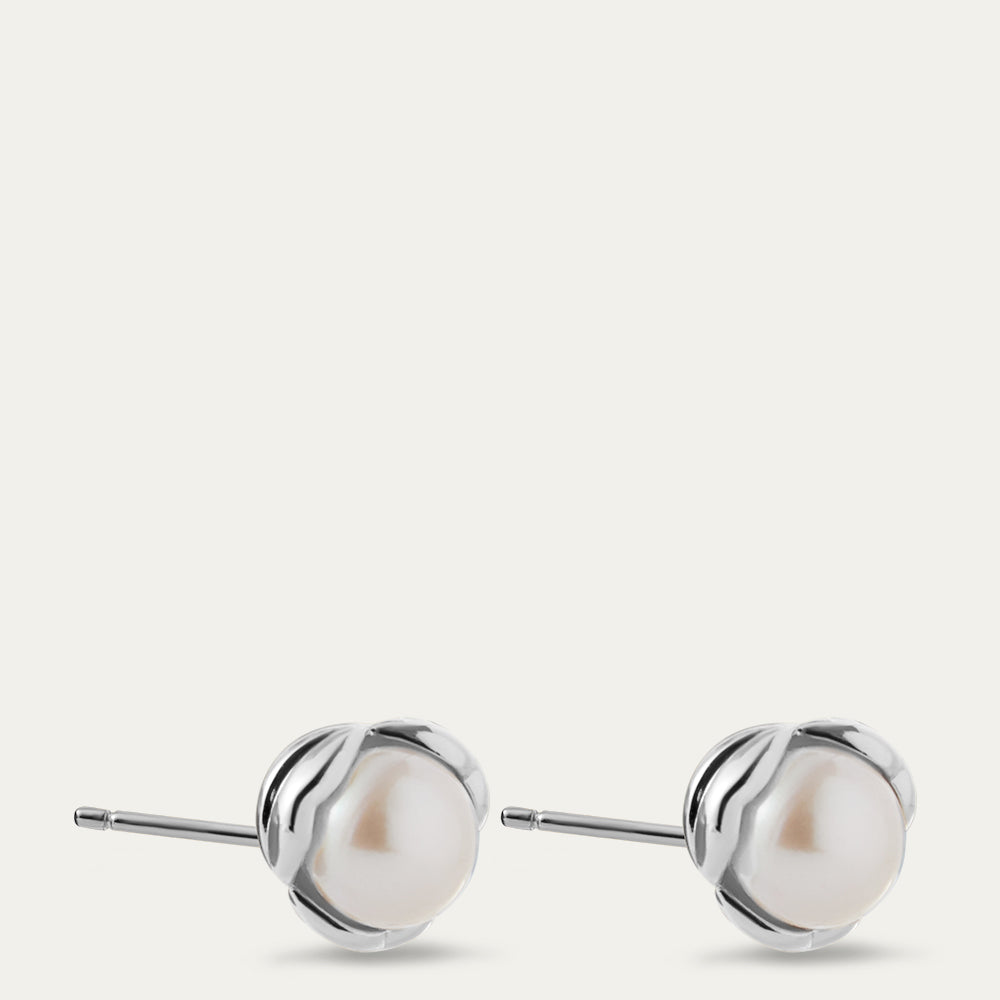 Pair of pearl earrings with silver settings on a white background