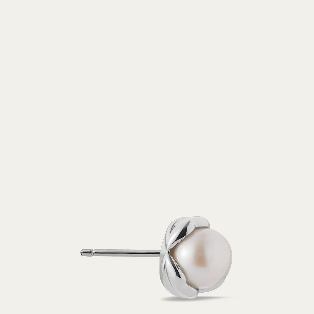 Pearl stud earring with silver setting on a light gray background