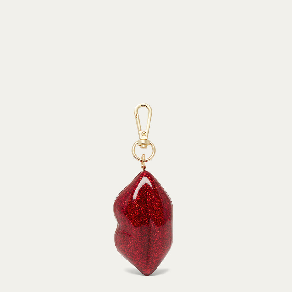 Red glittery lip-shaped keychain with gold clasp on a white background