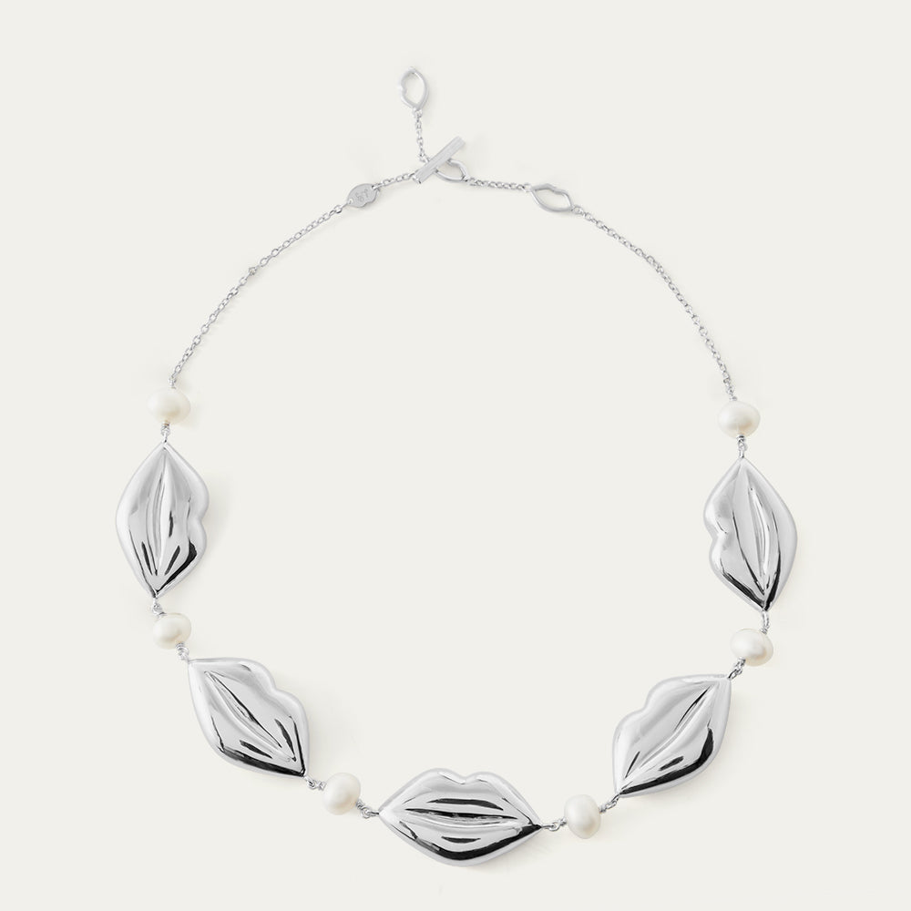 Silver lip shaped chain necklace with lip-shaped links and pearls.