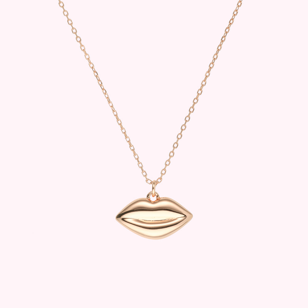 Rose gold lips necklace on a white background.
