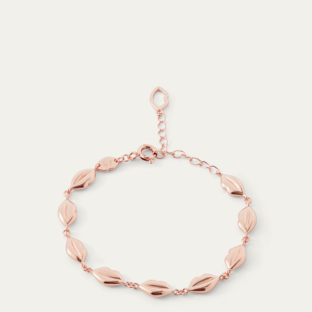 Rose gold lip chain bracelet on a light beige background