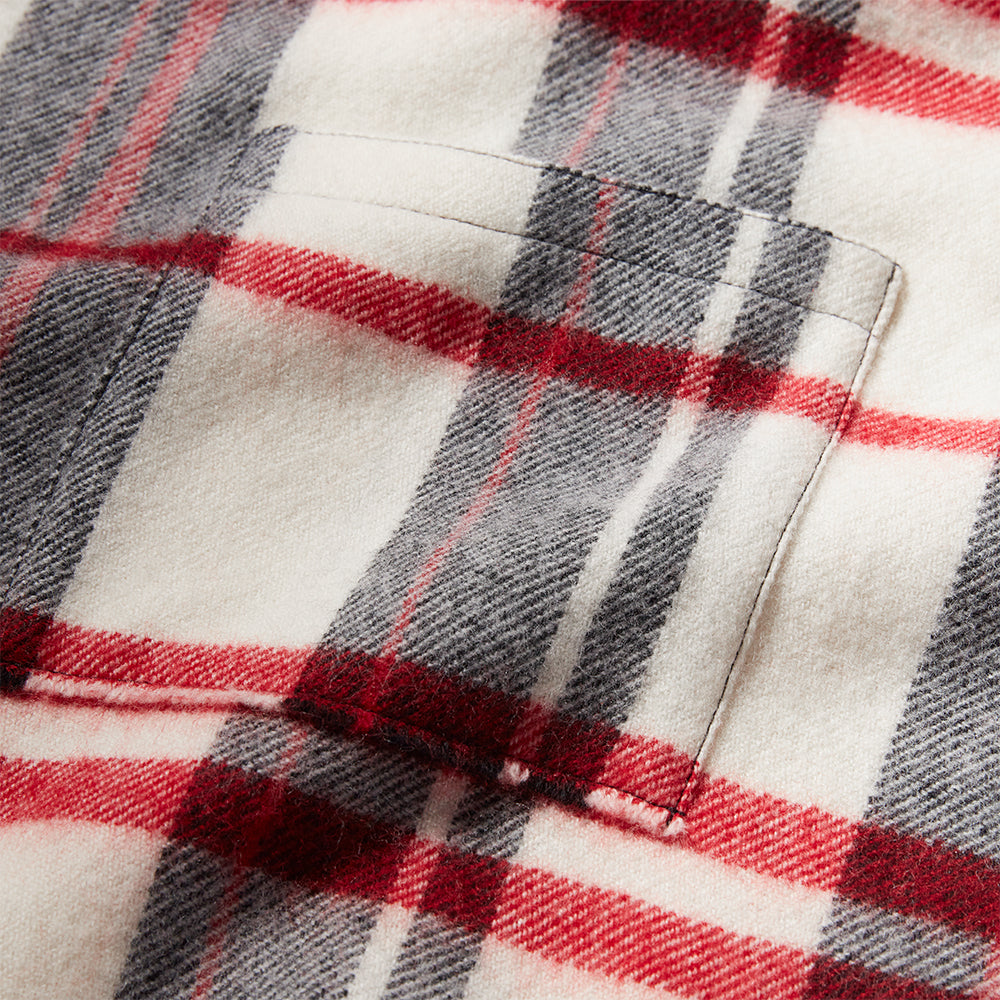 Close-up of a plaid fabric with red, gray, and white colors.