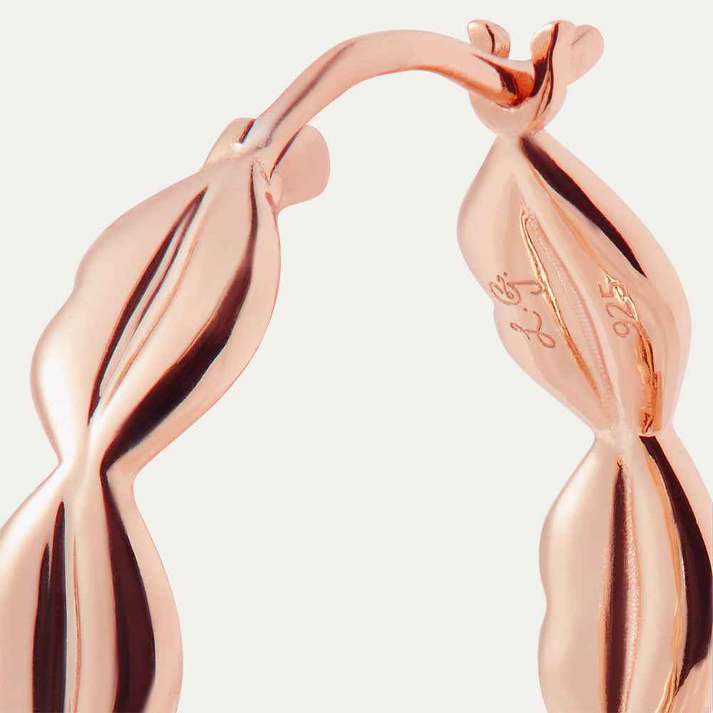 Rose gold hoop earrings on a light grey background