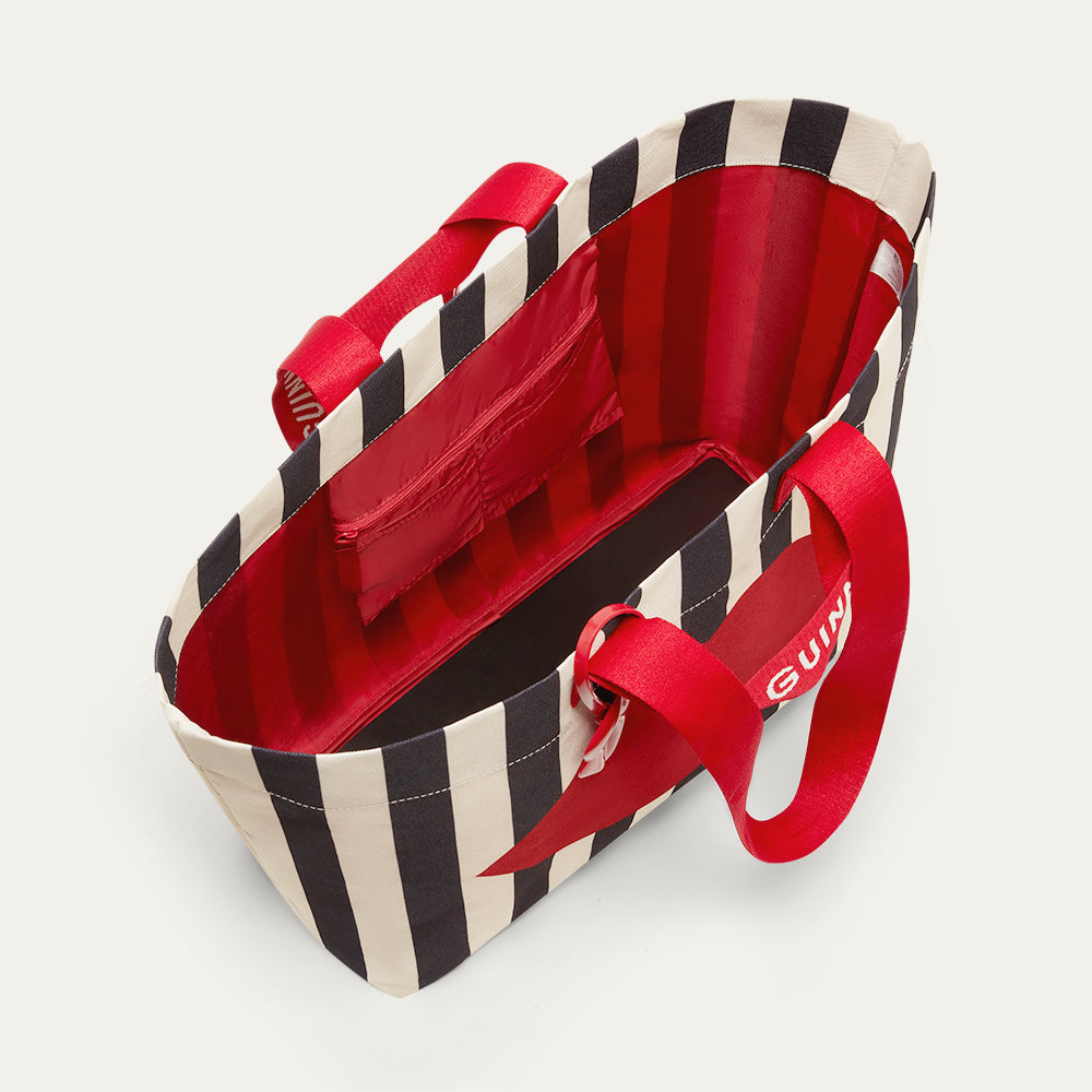 Inside image of a striped black and beige tote bag with red handles, showing the inside pocket on a light gray background