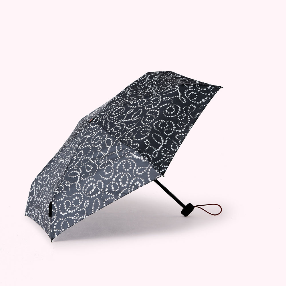 A black umbrella with a white pearl pattern, partially open, on a white background.
