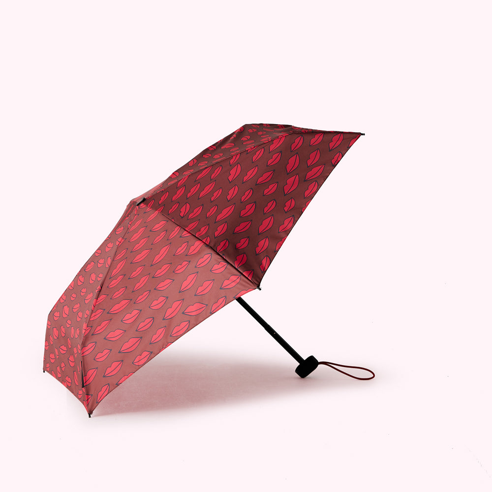 A red umbrella with a pattern of red lips on a maroon background.