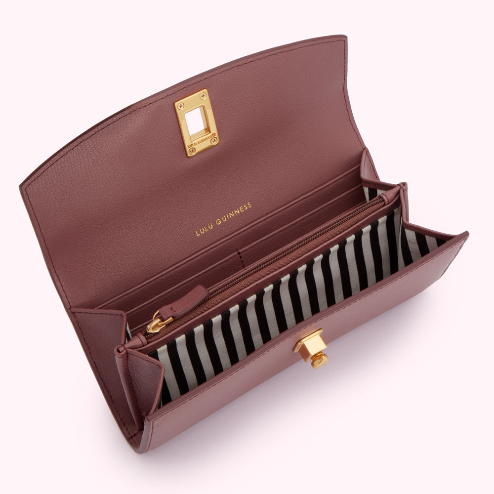 Open mauve Lulu Guinness wallet with black and white striped interior.