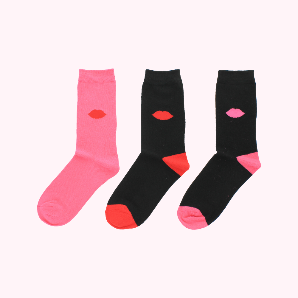 Three pairs of socks with a red lip print; one pair is pink, one is black, and the third is black and pink.