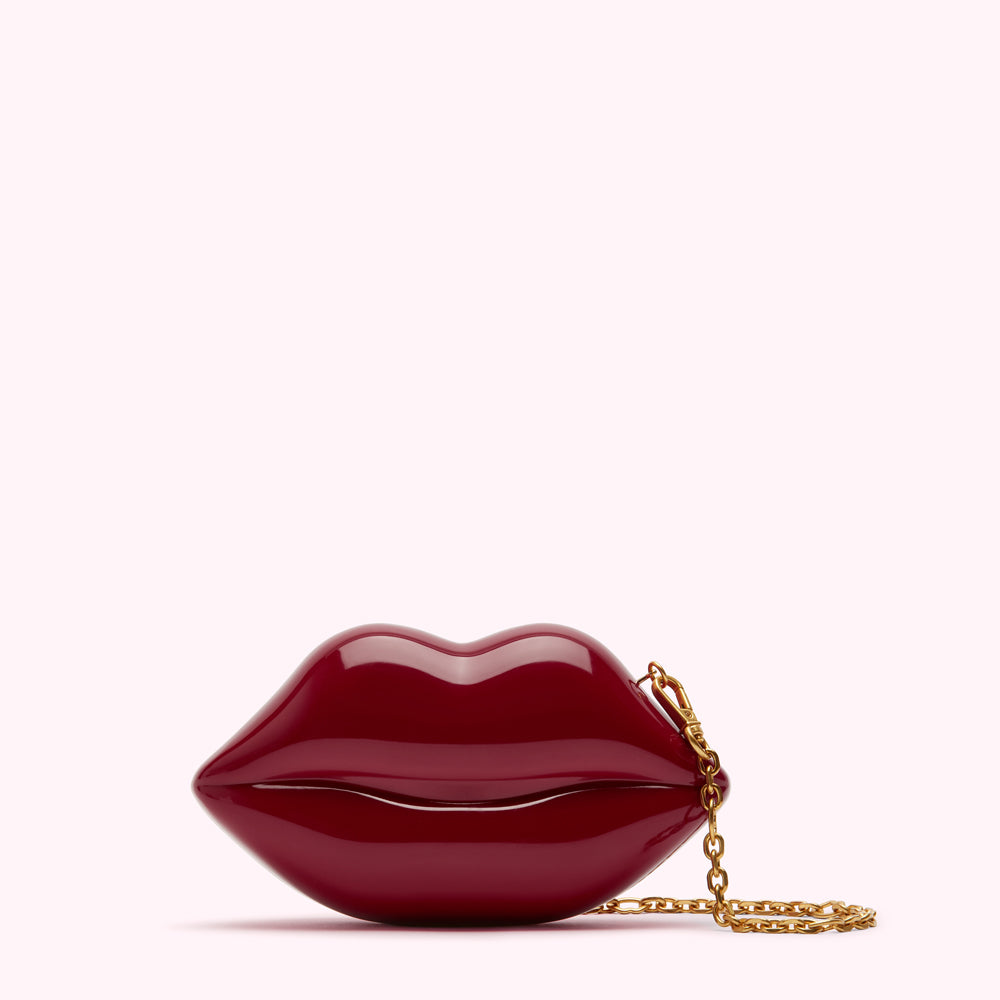 Red lip-shaped clutch with gold chain.
