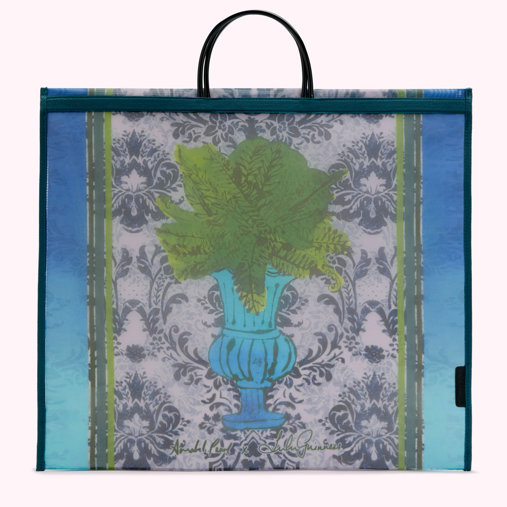 Large teal and blue tote bag with a design of ferns in an urn on a damask background. The bag has black handles and is designed by Annabel Pearl x Lulu Guinness.
